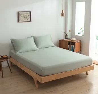 Zijaanzicht bamboe hoeslaken Sage Green (kleur licht groen) op een bed