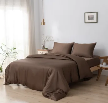 Bamboe dekbedovertrek en kussenslopen Coffee Brown (bruin) op een opgemaakt bed in een lichte slaapkamer, schuin aanzicht