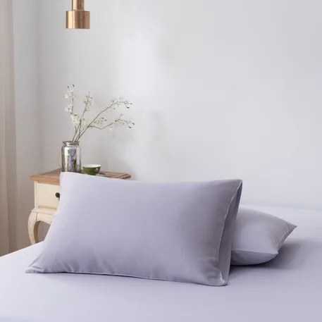 Twee bamboe kussenslopen Lavender Mist (lila) naast elkaar op een bed
