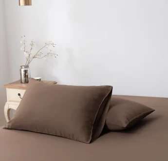 Twee bamboe kussenslopen Coffee Brown (bruin) naast elkaar op een bed