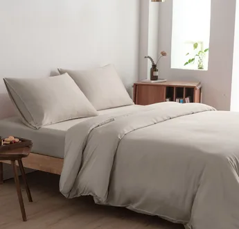 Bamboe beddengoedset Soft Taupe (taupe) op een opgemaakt tweepersoonsbed: dekbedovertrek, hoeslaken en kussenslopen