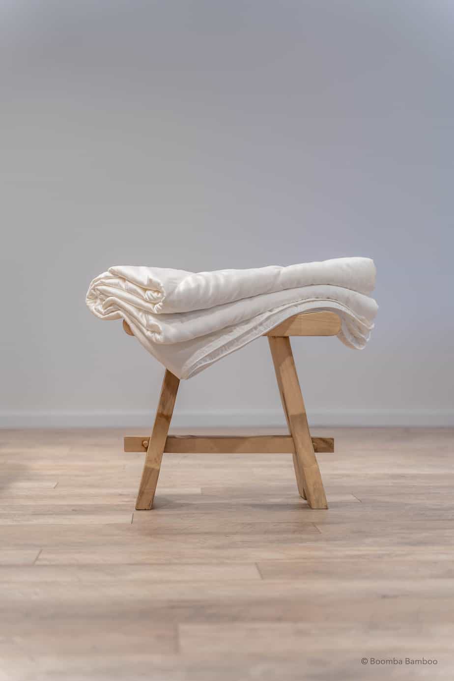 Beddengoed op een kruk, zijaanzicht van een bamboe dekbed