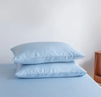 Foto van zijaanzicht van twee kussenslopen Sky Blue op een bed (kleur licht blauw)