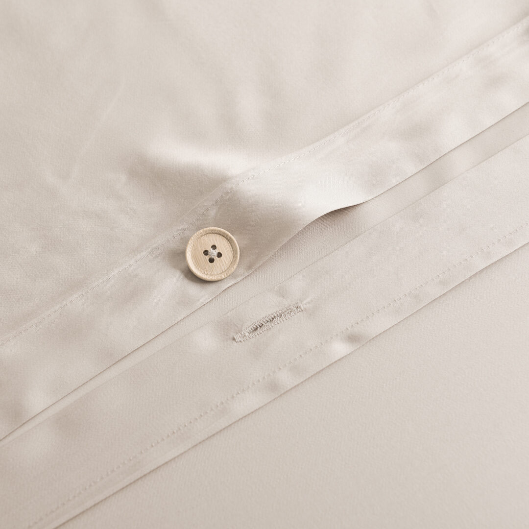 Detailfoto van een bamboe knoopsluiting van een bamboe dekbedovertrek in de kleur Soft Taupe (licht bruin)