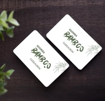 Twee Boomba Bamboo cadeaubonnen op een donkere houten ondergrond