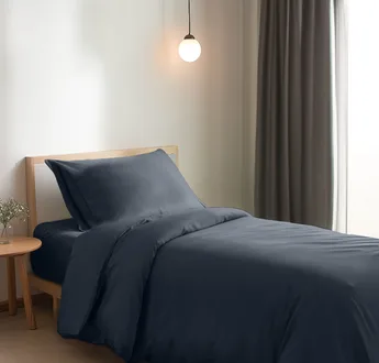 Bamboe dekbedovertrek Space Blue (donkerblauw) op een opgemaakt eenpersoonsbed