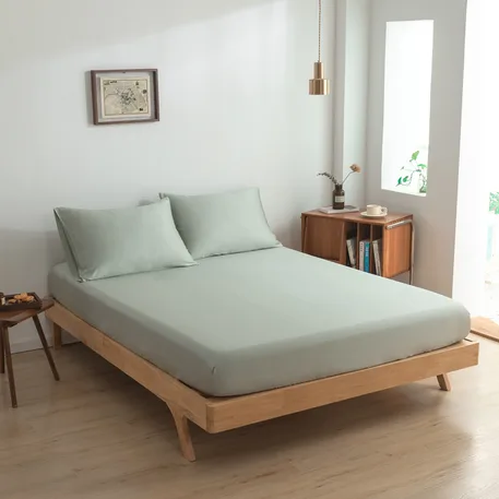 Zijaanzicht bamboe hoeslaken Sage Green (kleur licht groen) op een bed