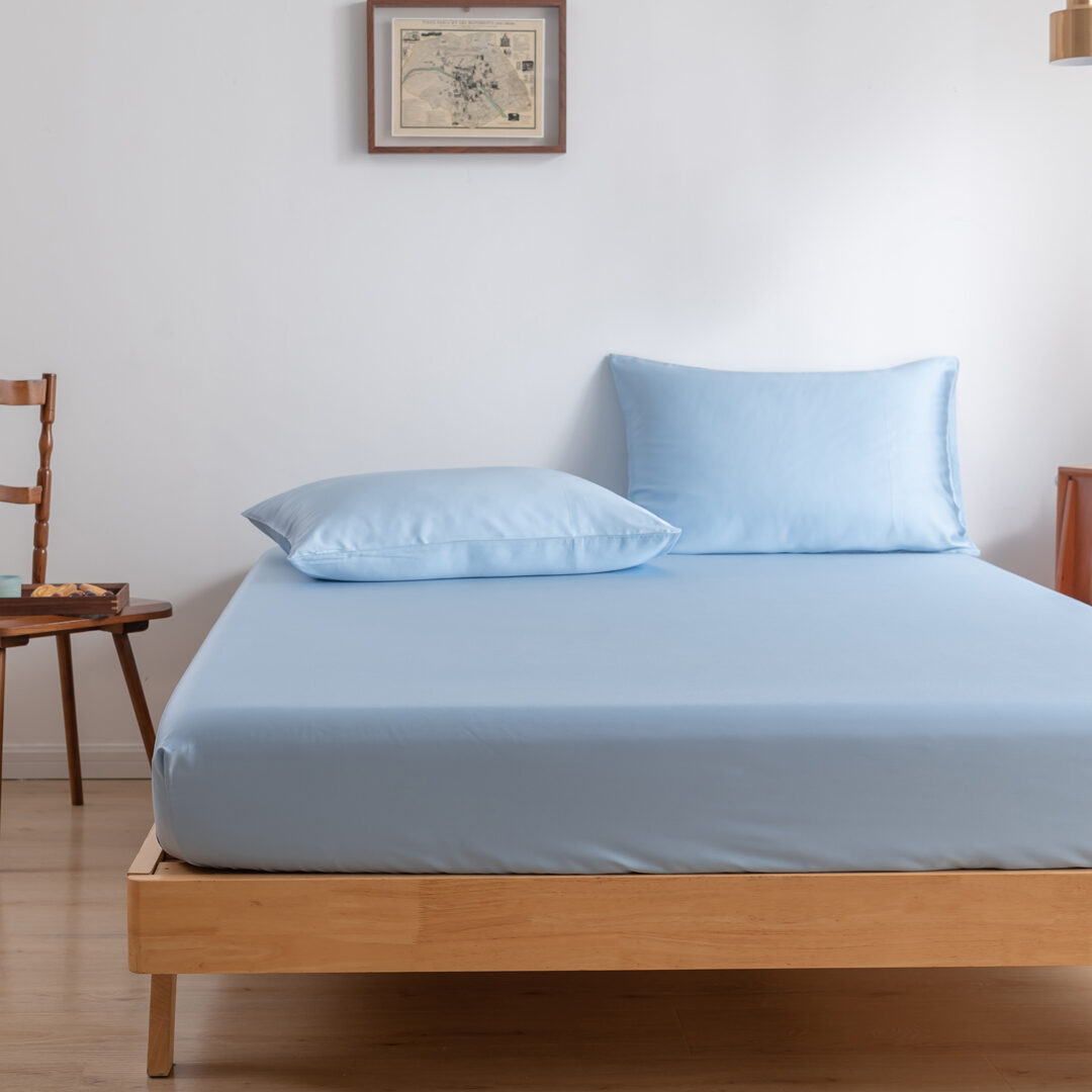 Twee kussenslopen Sky Blue op een bed als sfeerfoto (kleur licht blauw)