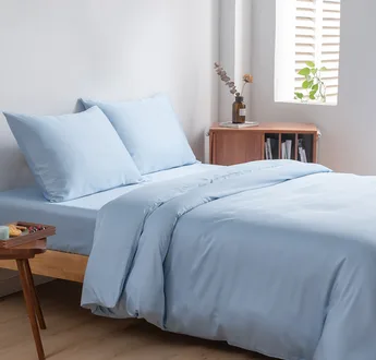 Bamboe beddengoedset Sky Blue (lichtblauw) op een opgemaakt tweepersoonsbed: dekbedovertrek, hoeslaken en kussenslopen