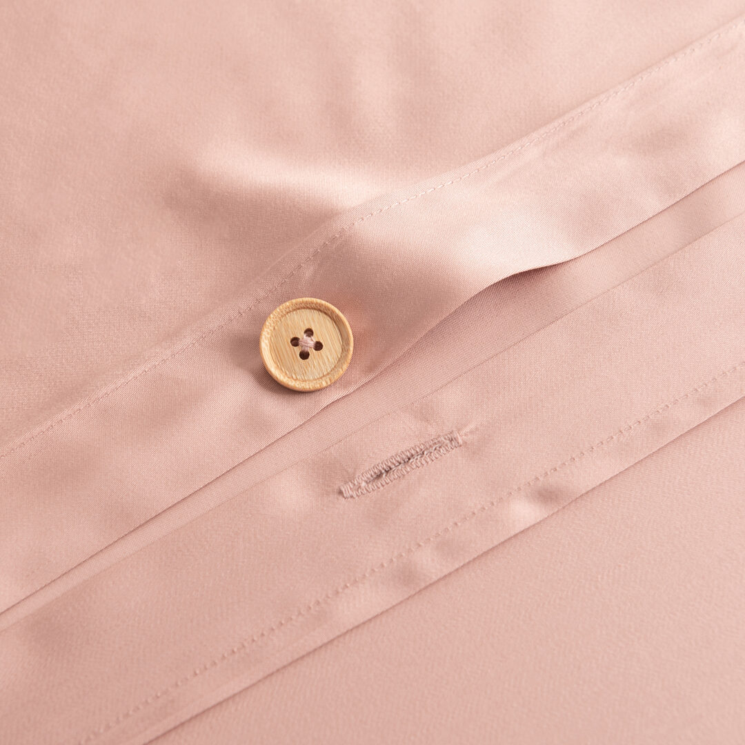 Detailfoto van een bamboe knoopsluiting van een bamboe dekbedovertrek in de kleur Cuddle Pink (licht roze)