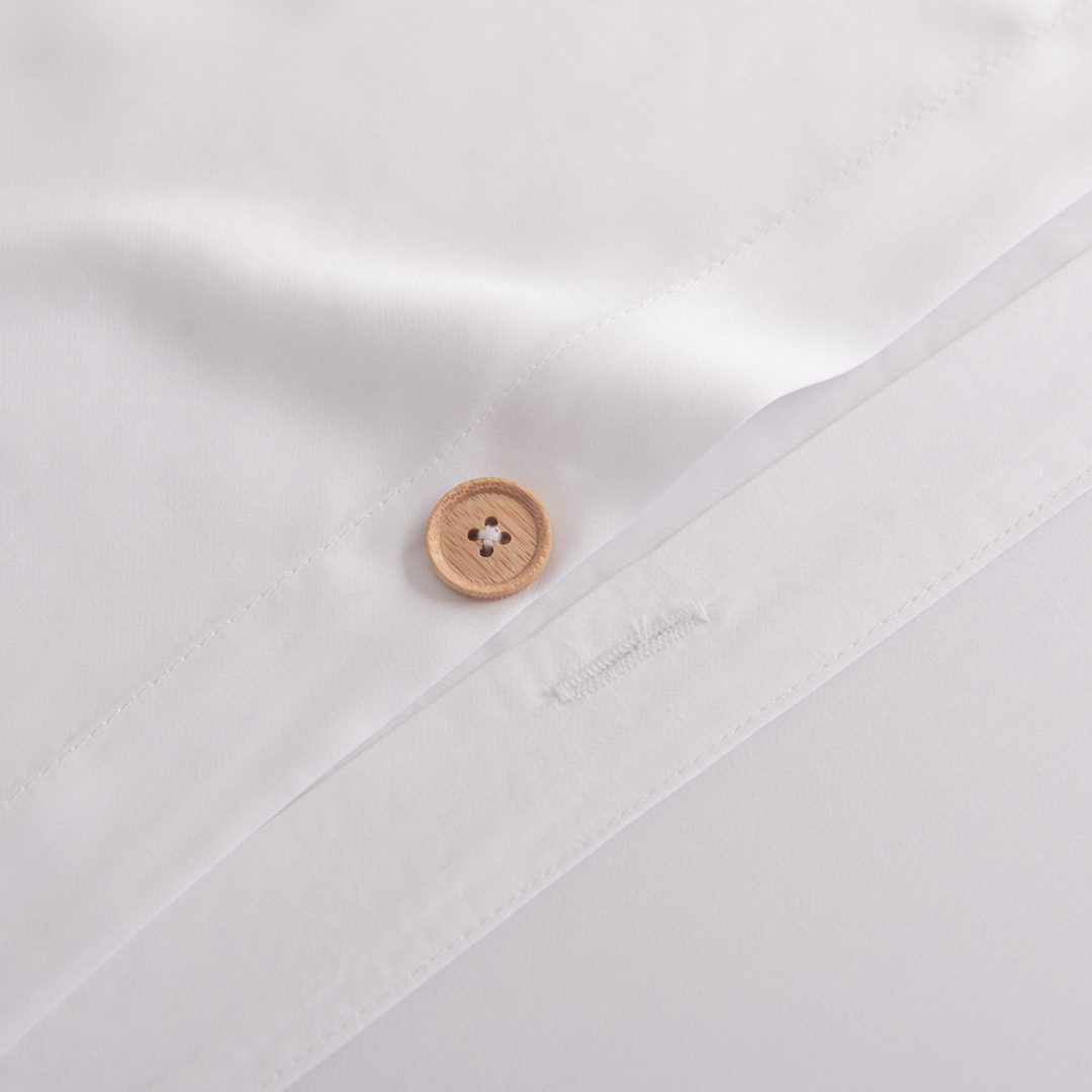 Detailfoto van een bamboe knoopsluiting van een bamboe dekbedovertrek in de kleur Coco White (kleur wit)